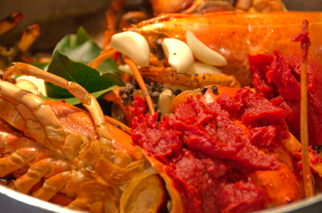 Roasted lobster shells and other ingredients go into the stockpot.